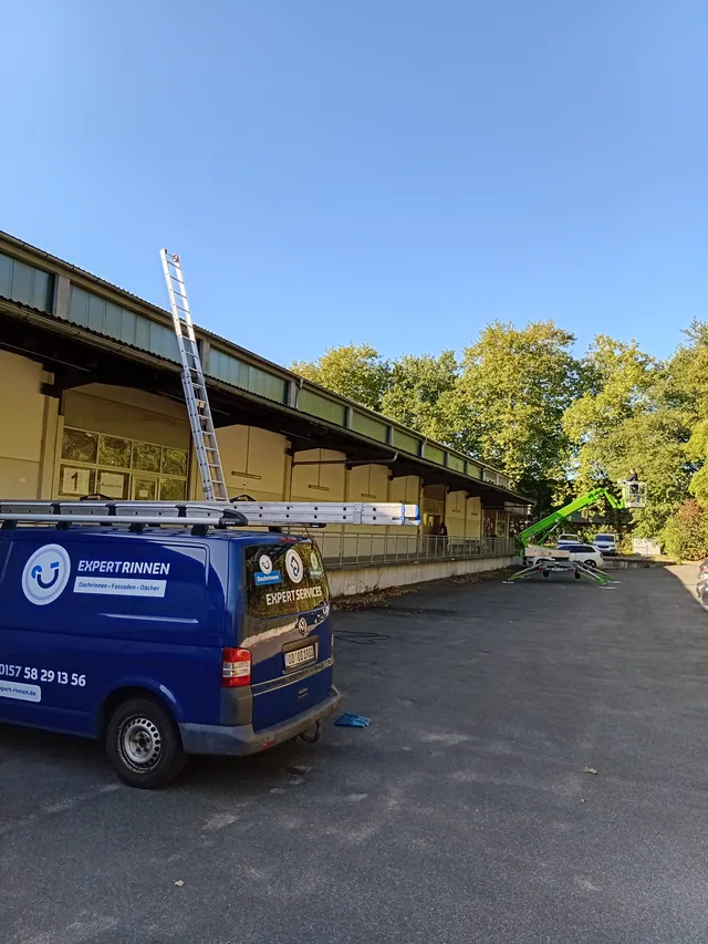Firmentransporter von ExpertRinnen mit Dachleiter vor einer Halle